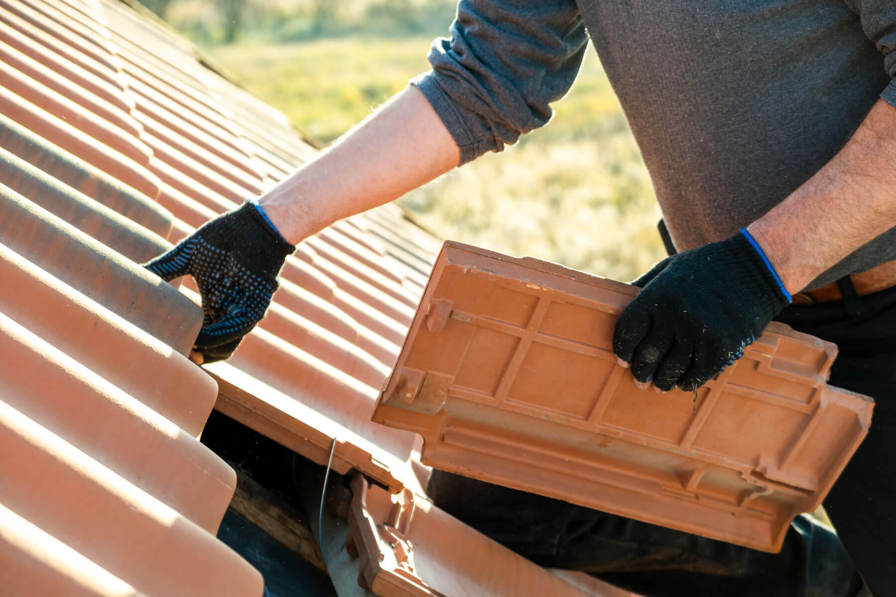 Closeup Of Worker Hands Installing Yellow Ceramic Roofing Tiles